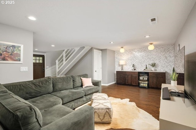 living area with wine cooler, wet bar, dark wood finished floors, stairway, and recessed lighting