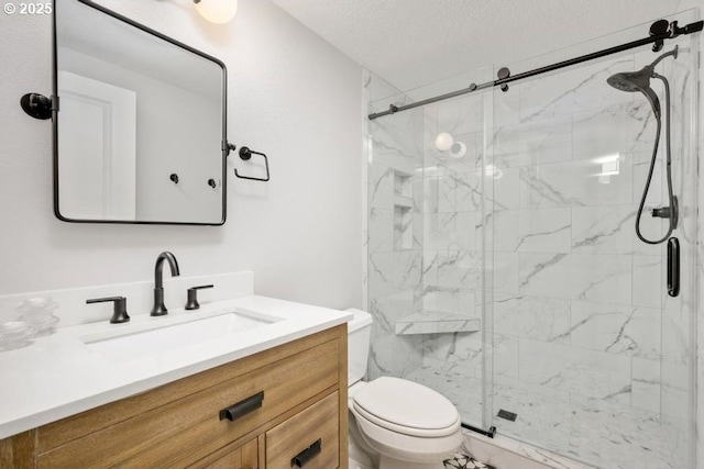 bathroom with toilet, a marble finish shower, vanity, and a textured ceiling