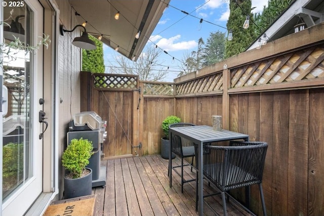 wooden deck featuring a grill and outdoor dining area