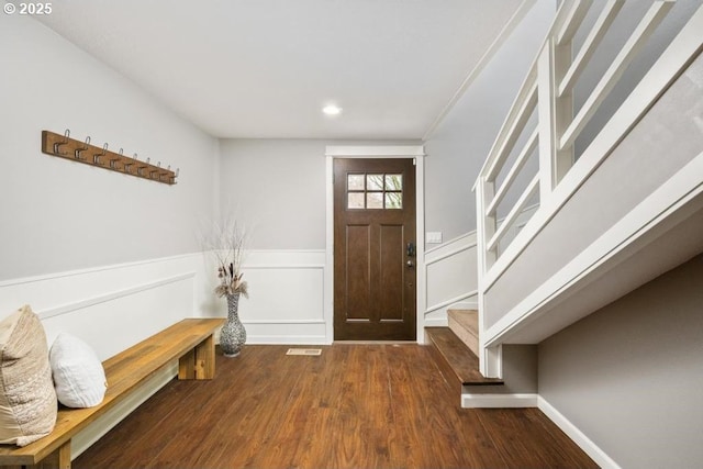 entryway featuring wood finished floors, stairs, wainscoting, recessed lighting, and a decorative wall
