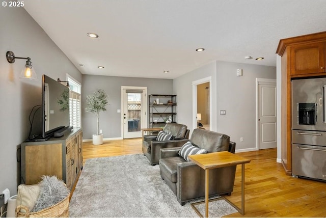 living room featuring light wood-style flooring, recessed lighting, and baseboards