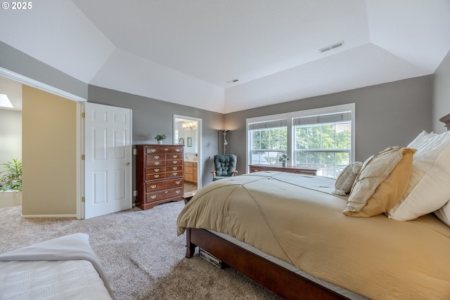 carpeted bedroom with vaulted ceiling and ensuite bath
