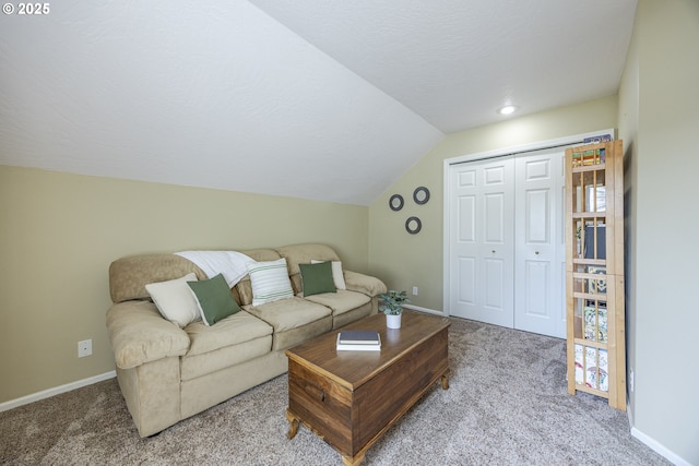 carpeted living area with vaulted ceiling and baseboards