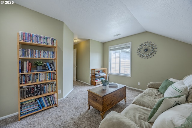 carpeted living area featuring lofted ceiling, a textured ceiling, and baseboards