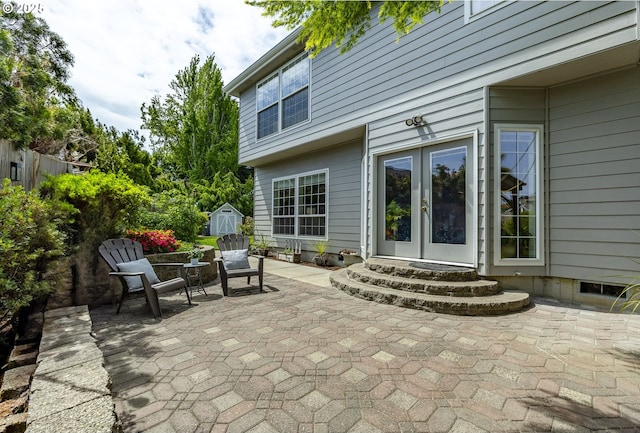 view of patio with french doors, a storage unit, and an outdoor structure