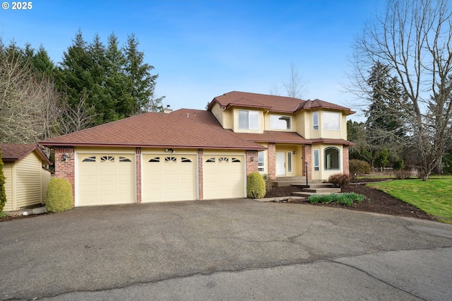 view of front facade featuring brick siding, an attached garage, and aphalt driveway