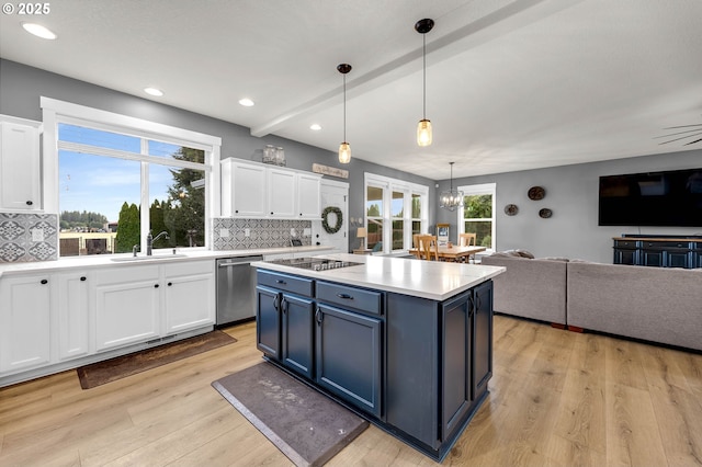kitchen featuring white cabinetry, blue cabinetry, open floor plan, and dishwasher