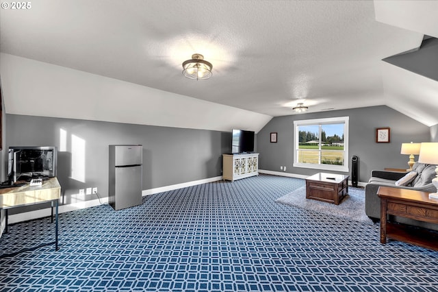 interior space featuring baseboards, dark colored carpet, a textured ceiling, and lofted ceiling