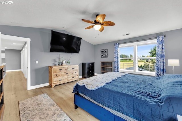 bedroom with visible vents, lofted ceiling, baseboards, a ceiling fan, and light wood-style flooring