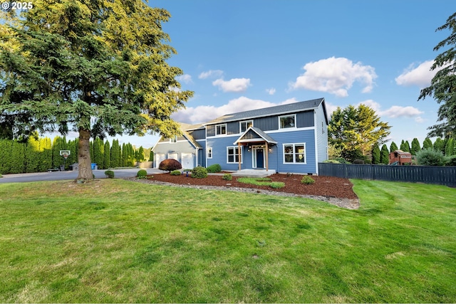 view of front of house featuring board and batten siding, driveway, fence, a front lawn, and an attached garage