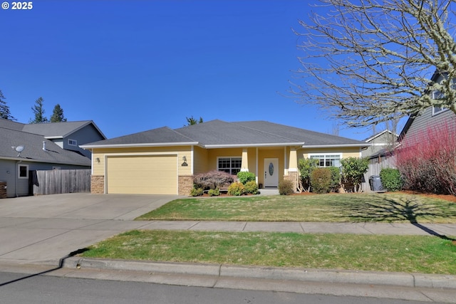 view of front facade featuring a shingled roof, concrete driveway, an attached garage, fence, and a front lawn