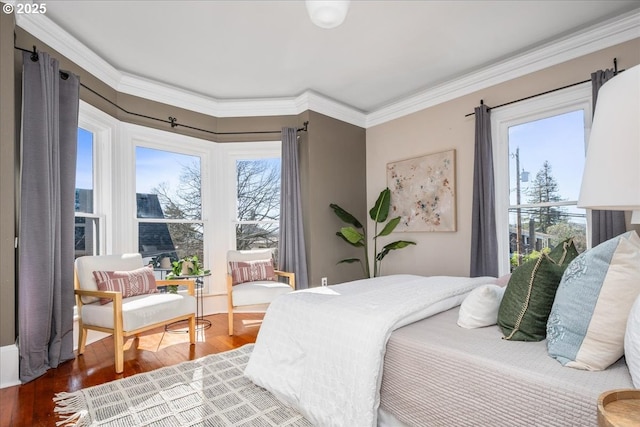 bedroom with wood finished floors and ornamental molding