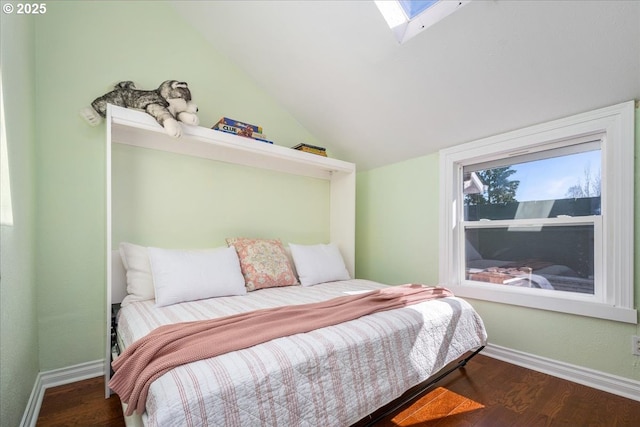 bedroom featuring lofted ceiling with skylight, wood finished floors, and baseboards