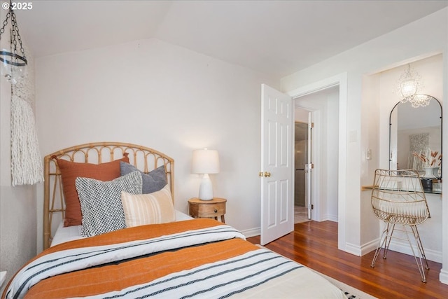 bedroom featuring baseboards, lofted ceiling, and wood finished floors