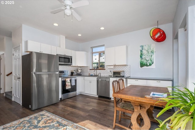 kitchen featuring decorative backsplash, appliances with stainless steel finishes, dark wood finished floors, and white cabinetry