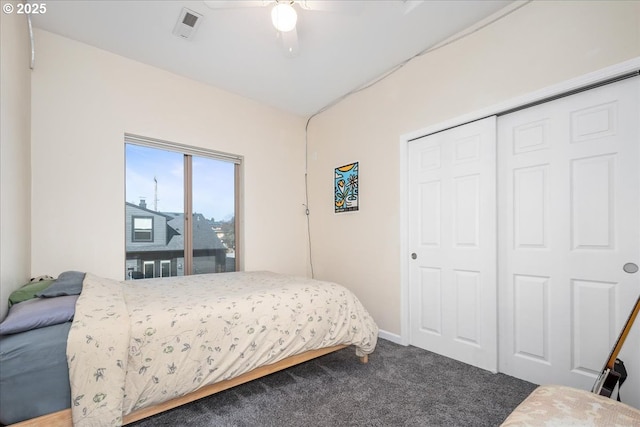 carpeted bedroom featuring a closet, visible vents, baseboards, and a ceiling fan