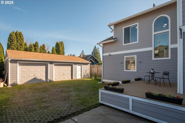 exterior space with a detached garage, an outdoor structure, and fence