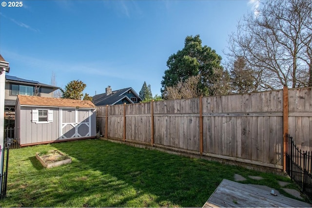 view of yard featuring an outbuilding, a storage unit, and a fenced backyard