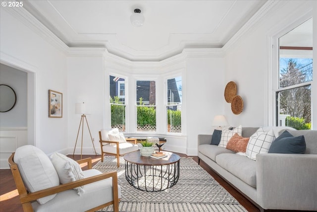 living area with baseboards, wood finished floors, and crown molding