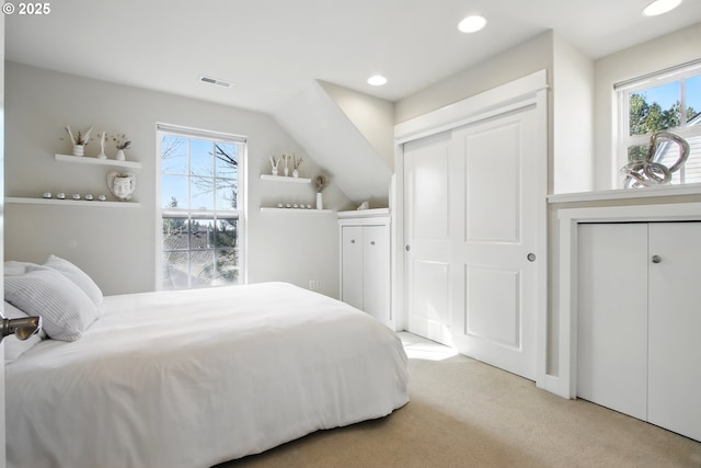 bedroom with recessed lighting, multiple windows, light colored carpet, and visible vents