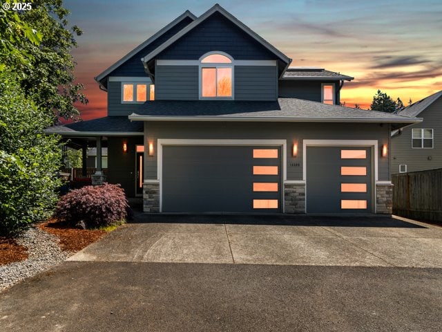 14509 SE Faircrest St, Clackamas, OR 97015 - view of front of house featuring driveway, stone siding, and an attached garage