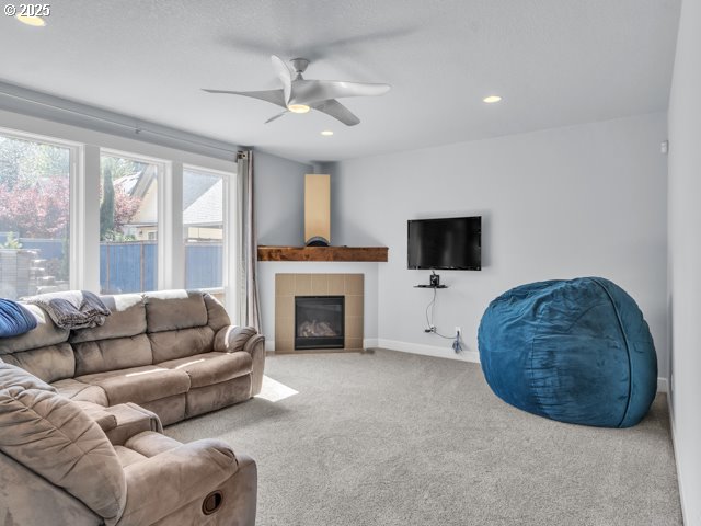 14509 SE Faircrest St, Clackamas, OR 97015 - living room with carpet flooring, a ceiling fan, a tiled fireplace, and recessed lighting