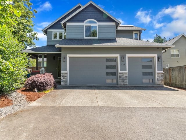 14509 SE Faircrest St, Clackamas, OR 97015 - craftsman-style house featuring stone siding, driveway, roof with shingles, and a garage