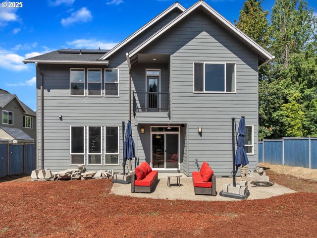 14509 SE Faircrest St, Clackamas, OR 97015 - back of house with a balcony, solar panels, a fenced backyard, and a patio