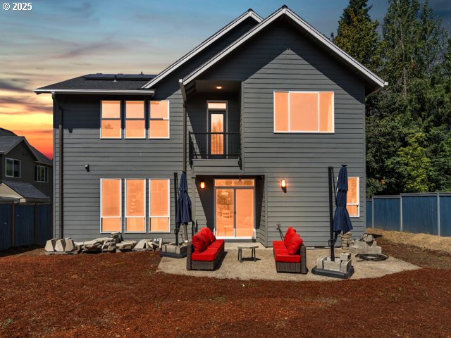 14509 SE Faircrest St, Clackamas, OR 97015 - back of house featuring a balcony, roof mounted solar panels, and a fenced backyard