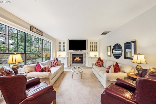 carpeted living room with a high end fireplace