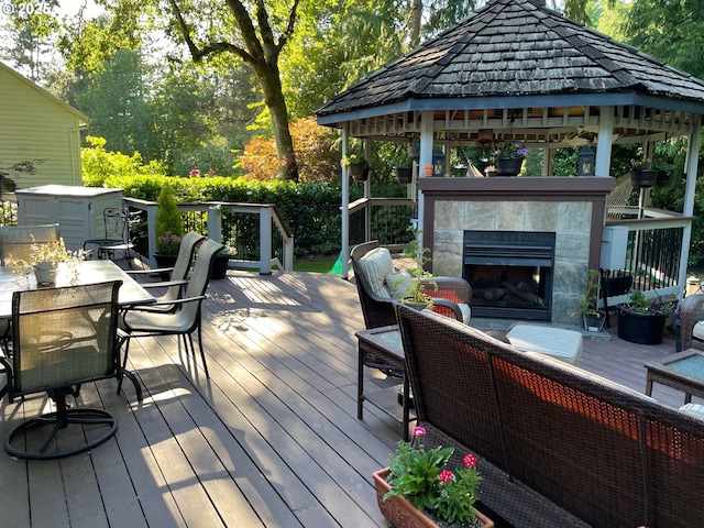 deck featuring a gazebo and an outdoor living space with a fireplace