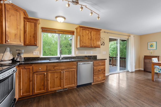 13420 SW 2nd St, Beaverton, OR 97005 - kitchen featuring appliances with stainless steel finishes, a sink, brown cabinets, dark wood-type flooring, and dark stone countertops