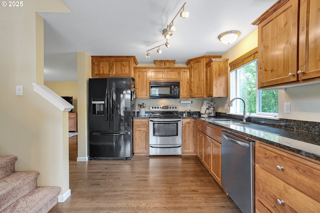 13420 SW 2nd St, Beaverton, OR 97005 - kitchen with black appliances, a sink, dark wood-type flooring, dark stone countertops, and brown cabinets