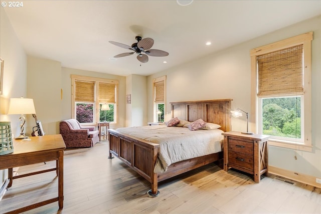 bedroom with multiple windows, ceiling fan, and light wood-type flooring