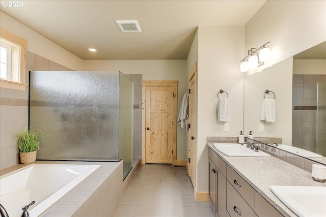 bathroom featuring vanity, shower with separate bathtub, and tile patterned flooring