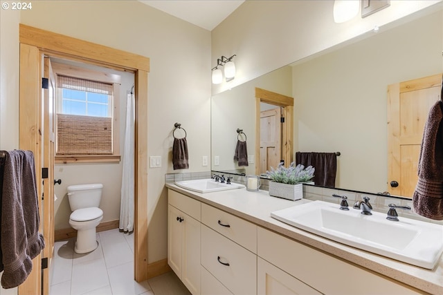 bathroom with tile patterned flooring, vanity, and toilet