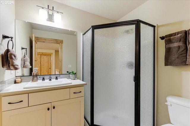 bathroom with a shower with door, vanity, and toilet