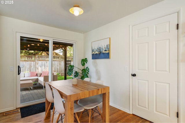 dining space featuring baseboards, visible vents, and wood finished floors