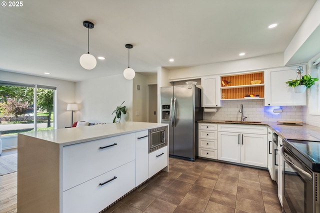 kitchen featuring a sink, decorative backsplash, stainless steel appliances, and white cabinets