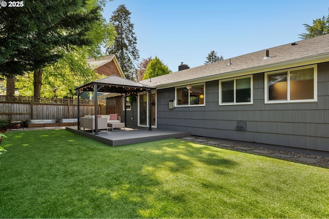 rear view of house featuring an outdoor living space, a chimney, a lawn, a gazebo, and fence