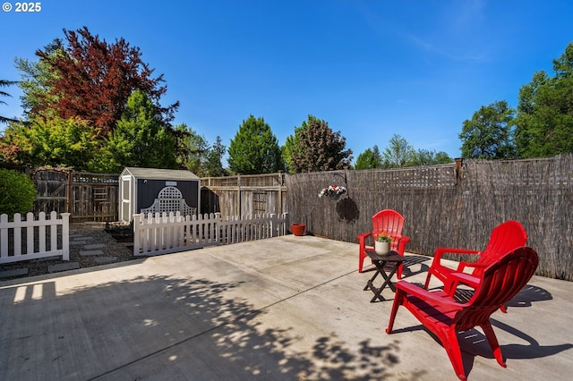 view of patio with a storage unit, a fenced backyard, and an outbuilding
