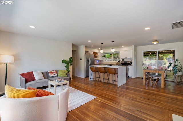 living room featuring visible vents, recessed lighting, and dark wood-style flooring