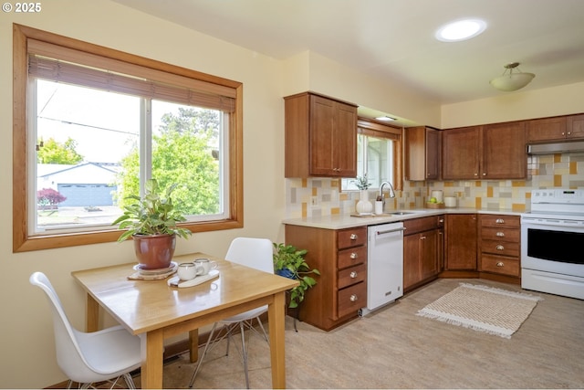 3132 SE 58th Ave, Portland, OR 97206 - kitchen featuring white appliances, under cabinet range hood, brown cabinetry, and decorative backsplash
