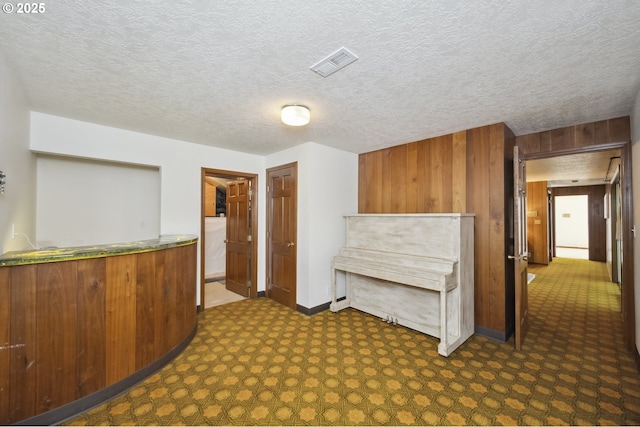 10776 SE Idleman Rd, Happy Valley, OR 97086 - interior space with wood walls, baseboards, dark carpet, brown cabinets, and a textured ceiling