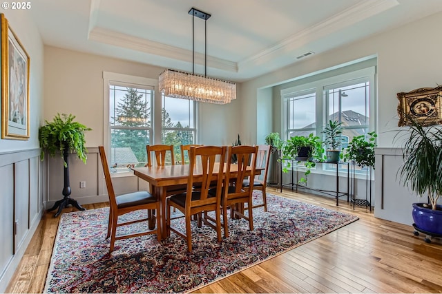 dining room with ornamental molding, a tray ceiling, and plenty of natural light