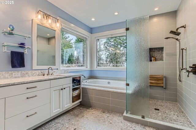 bathroom with a bath, vanity, tiled shower, and recessed lighting