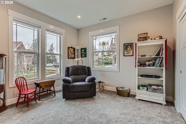sitting room featuring carpet, baseboards, a healthy amount of sunlight, and visible vents
