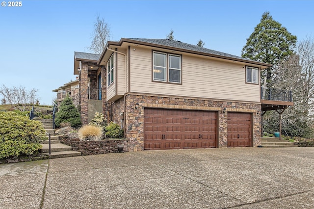 view of side of home with stairway, an attached garage, and stone siding