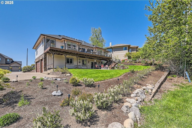 back of property with a lawn, driveway, an attached garage, stairs, and a wooden deck