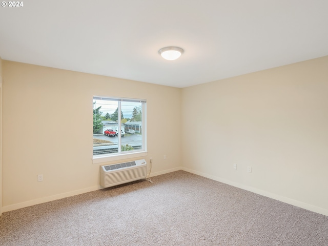 spare room with a wall mounted air conditioner and carpet floors